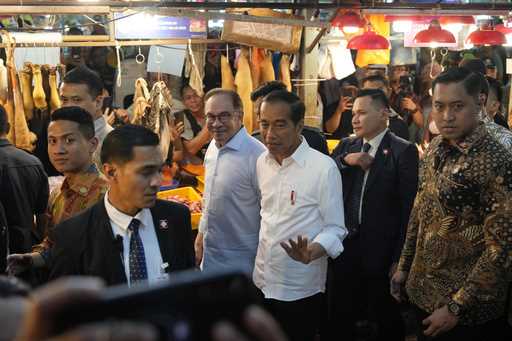 Indonesian President Joko Widodo, center, walks with Malaysian Prime Minister Anwar Ibrahim as they…