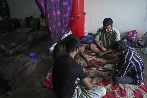Bangladeshi migrant workers play cards in a dormitory in Klang, Malaysia, Friday, January 24, 2025