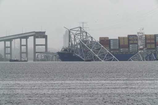 A container ship rests against the wreckage of the Francis Scott Key Bridge on Thursday, March 28, …