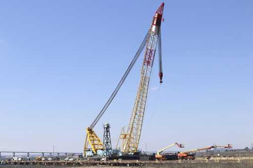 A crane is seen near the wreckage of the Francis Scott Key Bridge on Friday, March 29, 2024 in Balt…