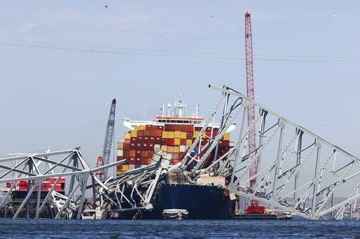 The collapsed Francis Scott Key Bridge lay on top of the container ship Dali, Monday, April 15, 202…