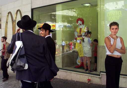Residents of Jerusalem mingle inside and outside of the city's downtown McDonald's fast food restau…