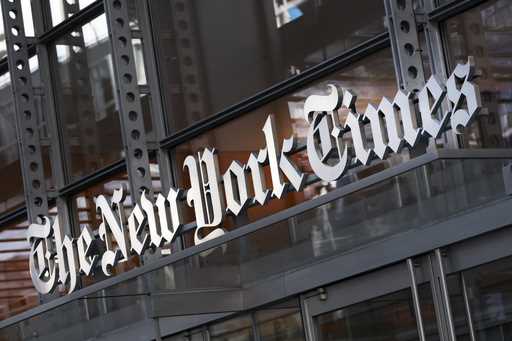 A sign for The New York Times hangs above the entrance to its building, May 6, 2021, in New York