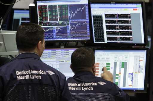 A pair of Bank of America-Merrill Lynch specialists work at their post on the floor of the New York…
