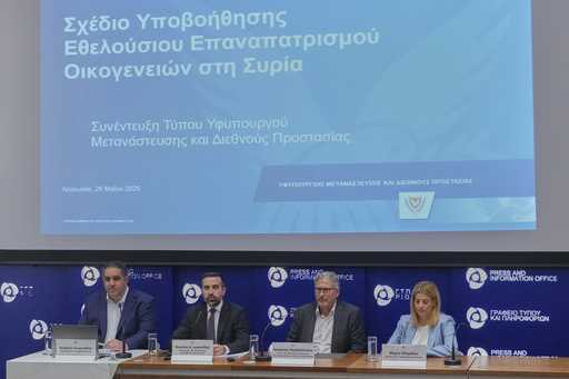 Cyprus' deputy minister for migration Nicholas Ioannides, second left, explains how a new voluntary…