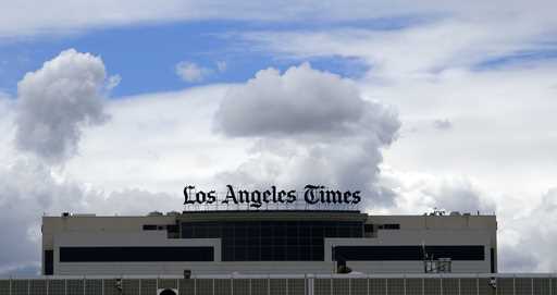The Los Angeles Times building is seen behind a fence behind the Los Angeles International Airport,…