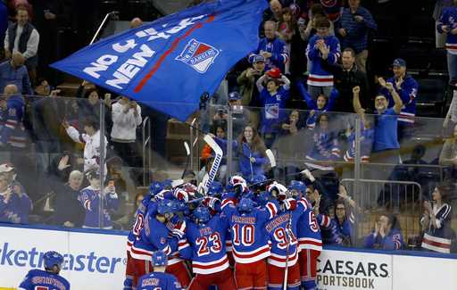 The New York Rangers and fans celebrate a shootout victory over the New York Islanders in an NHL ho…