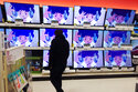 A shopper looks at televisions in a store in Indianapolis on Friday, November 26, 2021