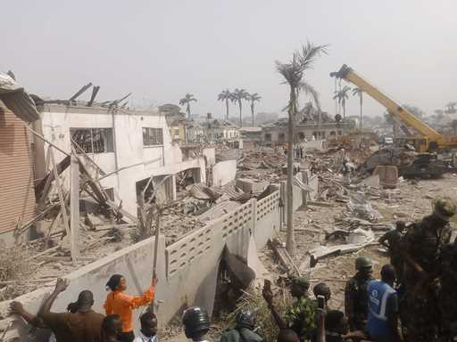 People gather at the site of an explosion in Ibadan, Nigeria, Wednesday, January 17, 2024
