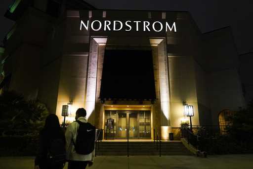 Two pedestrians walk near an entrance to a Nordstrom department store at the Grove mall in Los Ange…