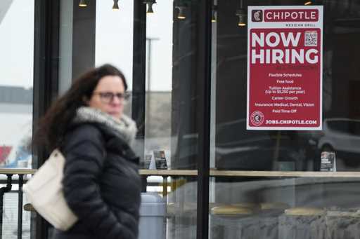 A hiring sign is displayed at a Chipotle restaurant in Schaumburg, Ill