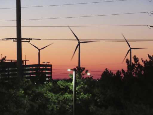 The sun sets behind spinning land-based wind turbines in Atlantic City, N
