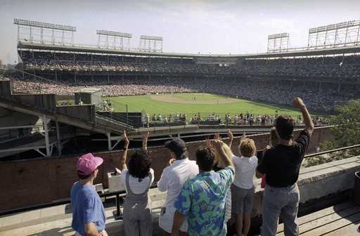 In this Monday, July 9, 1990, file photo, spectators watch an All-Star Game practice session from t…