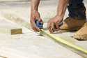 A beam is measured and marked at a housing site in Madison County, Miss