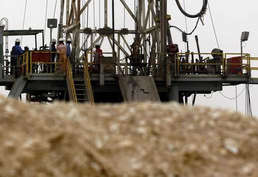 Oil workers stand on a new rig Tuesday, June 17, 2008, in the Sakhir, Bahrain, desert