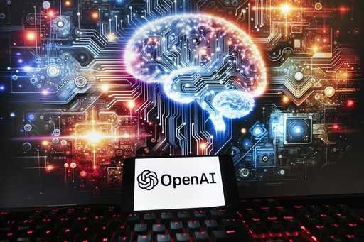 The OpenAI logo is seen displayed on a cell phone with an image on a computer monitor generated by …