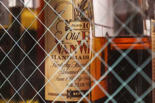 A bottle of Old Pappy Van Winkle bourbon, a 10-year-old, is shown behind glass doors at a whiskey b…