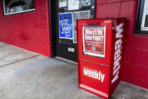 A red Eugene Weekly newspaper distributor box stands outside its office in Eugene, Ore