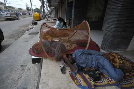 Laborers sleep on the roadside during an early hot summer morning in Karachi, Pakistan, Wednesday, …