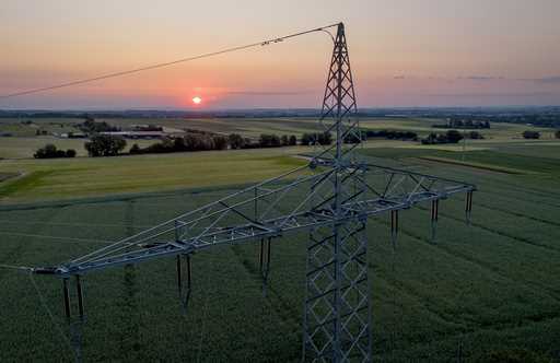 A transmission tower stands on a field in the outskirts of Frankfurt, Germany, as the sunrises on J…