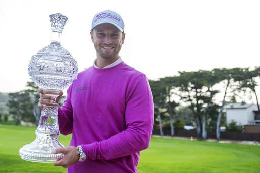 Wyndham Clark holds the trophy after winning the AT&T Pebble Beach National Pro-Am golf tournament …