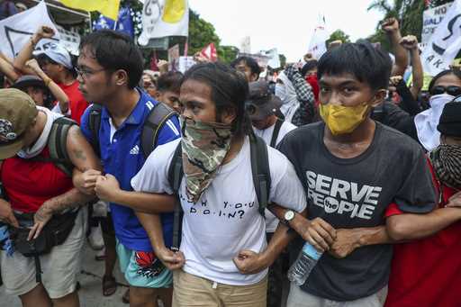 Filipino workers carry streamers and posters during a protest to mark International Labor Day near …