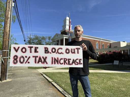 Rob Romeijn protests property taxes outside Rockdale County offices in Conyers, Ga