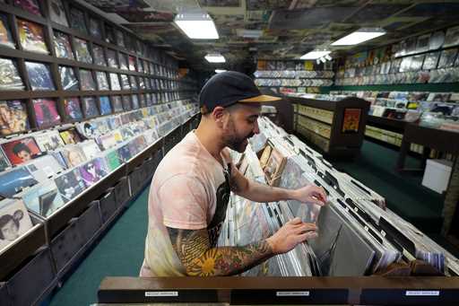 Jeff Maimon, of Chicago, checks out some vinyl at Tracks In Wax record shop, Thursday, April 18, 20…