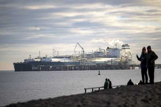 The tanker Maria Energy, left, loaded with liquefied natural gas, is moored at the floating termina…