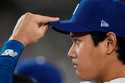 Los Angeles Dodgers' Shohei Ohtani watches from the dugout during the fifth inning in Game 1 of the…