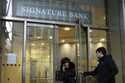 A woman leaves a branch of Signature Bank in New York, Monday, March 13, 2023