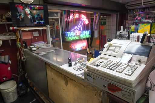 A cash register is seen on the front counter at the Alpha Shoe Repair Corp