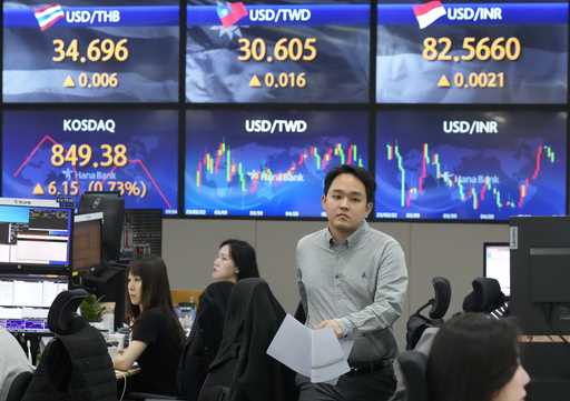 A currency trader passes by the screens showing the foreign exchange rates at the foreign exchange …