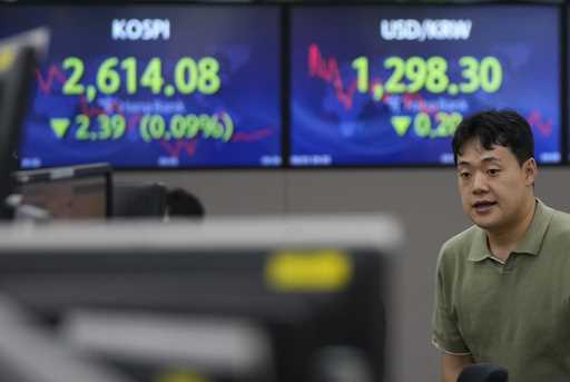 A currency trader gestures in front of the screens showing the Korea Composite Stock Price Index…
