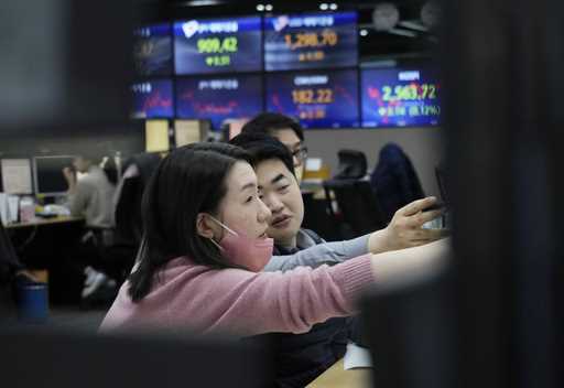 Currency traders work at the foreign exchange dealing room of the KEB Hana Bank headquarters in Seo…