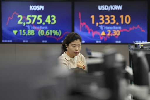 A currency trader watches monitors near the screens showing the Korea Composite Stock Price Index…