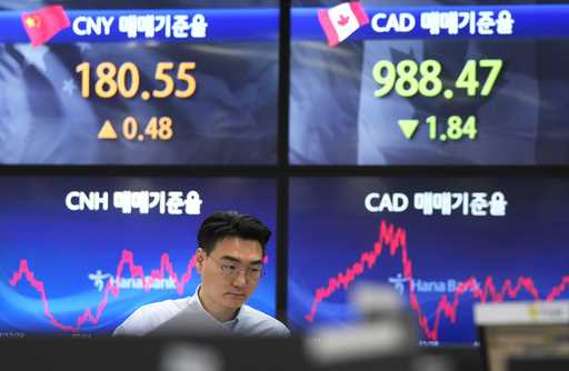 A currency trader watches monitors at the foreign exchange dealing room of the KEB Hana Bank headqu…