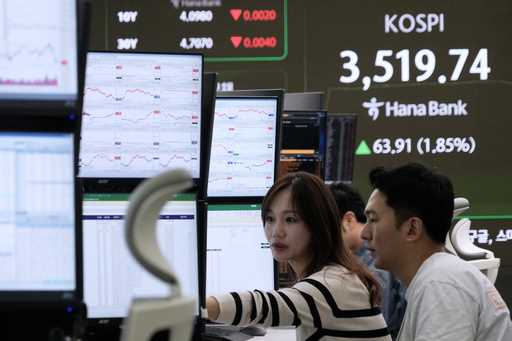 Currency traders watch monitors near a screen showing the Korea Composite Stock Price Index…