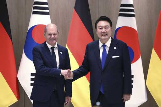 German Chancellor Olaf Scholz, left, and South Korea's President Yoon Suk Yeol shake hands before t…