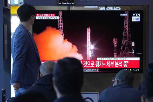 A TV screen shows a file image of North Korea's rocket launch during a news program at a bus termin…