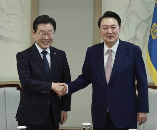 South Korean President Yoon Suk Yeol, right, shakes hands with main opposition Democratic Party lea…