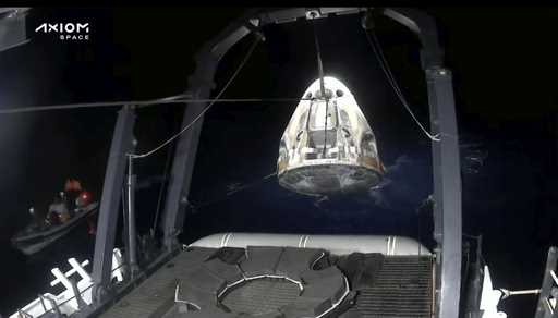 In this frame grab from video broadcast by SpaceX, recovery crews lift and secure the SpaceX Dragon…