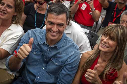 Spain's Prime Minister Pedro Sanchez next to his wife Begona Gomez, gives a thumb up during a campa…