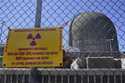 A sign on a fence warns of radioactive materials at a containment building housing a nuclear reacto…