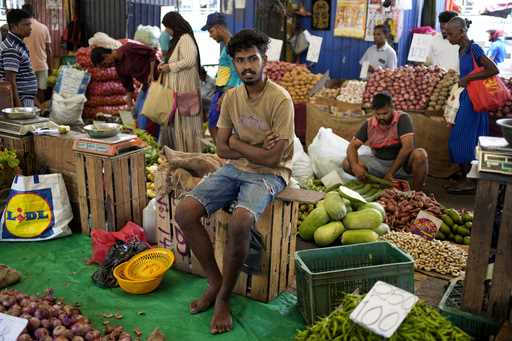 A vendor waits for customers at a market place in Colombo, Sri Lanka, Thursday, June