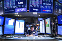 In this photo provided by the New York Stock Exchange, trader Matthew Cheslock works on the floor, …