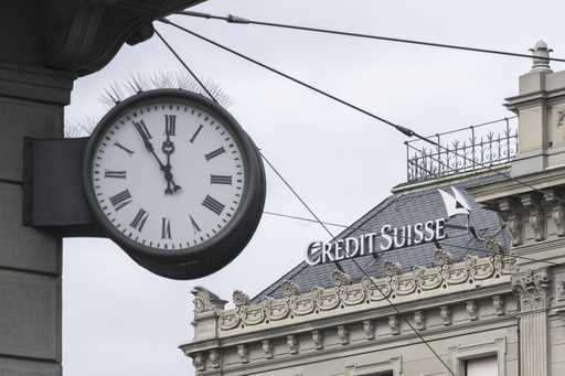 The logos of the Swiss banks UBS and Credit Suisse are displayed on different buildings in Geneva, …