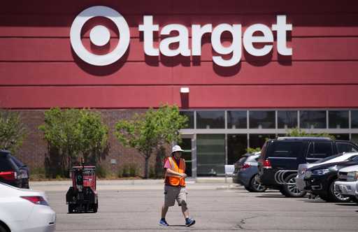 A worker collects shopping carts in the parking lot of a Target store June 9, 2021, in Highlands Ra…