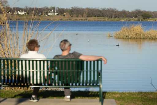 A couple sit along a trail overlooking White Rock Lake in Dallas on February 24, 2024