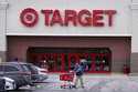 A shopper wheels his shopping cart through the parking lot after making a purchase at the Target st…